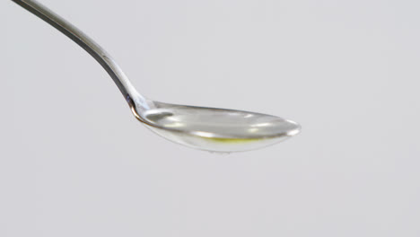 Green-olive-falling-on-the-spoon-with-olive-oil