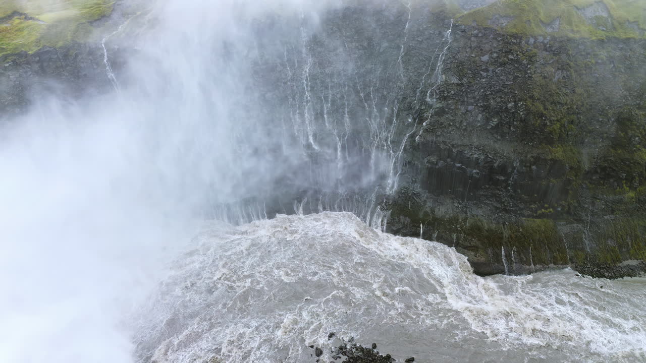 Drönarvy över vattenfallet Hafragilsfoss, beläget nedströms från Dettifoss. Kraftfullt forsande vatten flyter genom en brant vulkanisk kanjon omgiven av skiktade basaltklippformationer.