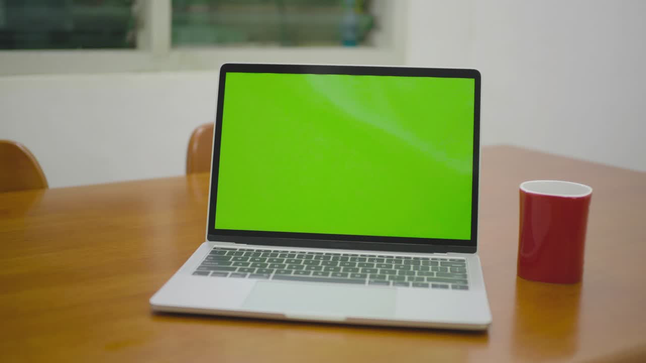 Ripresa con slider di un laptop con schermo verde appoggiato sulla scrivania