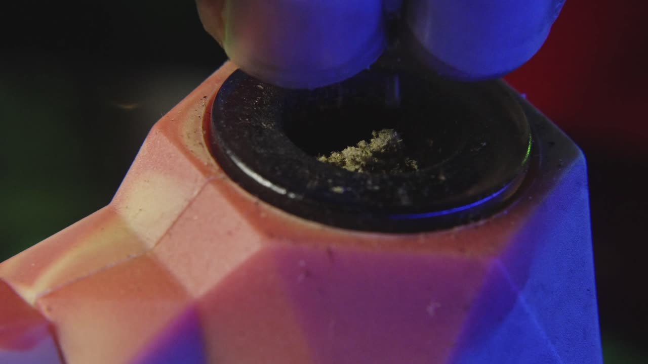 una toma de cerca de la ruptura de la marihuana en una pipa de goma para ser fumada