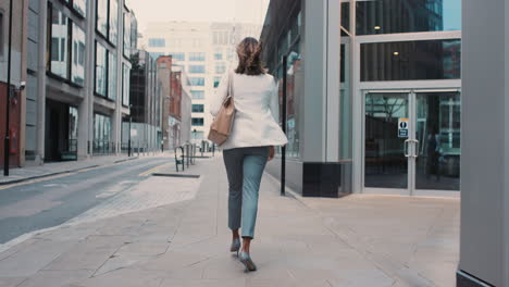 beautiful mixed race business woman walking through city