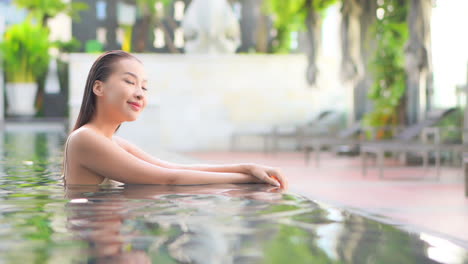 Mujer-Asiática-Exótica-Bastante-Sexy-En-La-Piscina-Del-Centro-De-Spa-Disfrutando,-Relajándose-Con-Una-Sonrisa,-Cámara-Lenta-De-Fotograma-Completo