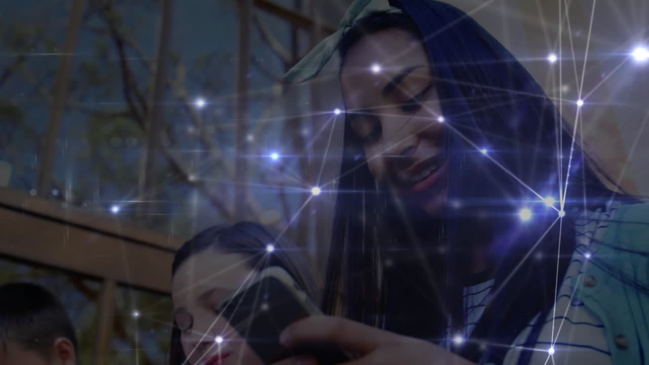 red brillante de conexiones contra un grupo de estudiantes que usan teléfonos inteligentes