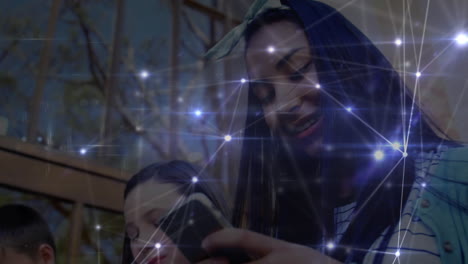 red brillante de conexiones contra un grupo de estudiantes que usan teléfonos inteligentes
