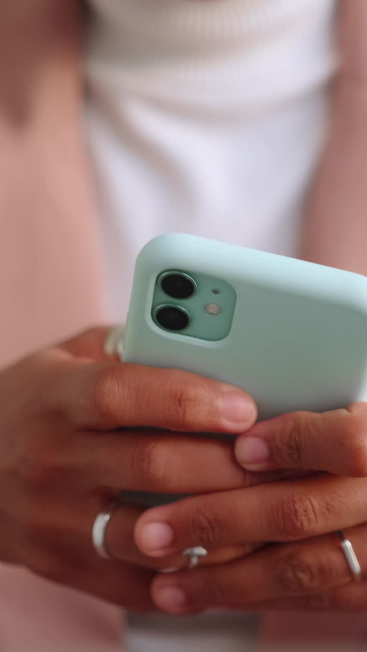 Closeup of hands holding smartphone texting and scrolling on a mobile device