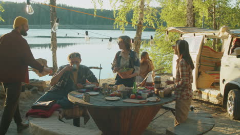 friends preparing food at lakeshore campsite