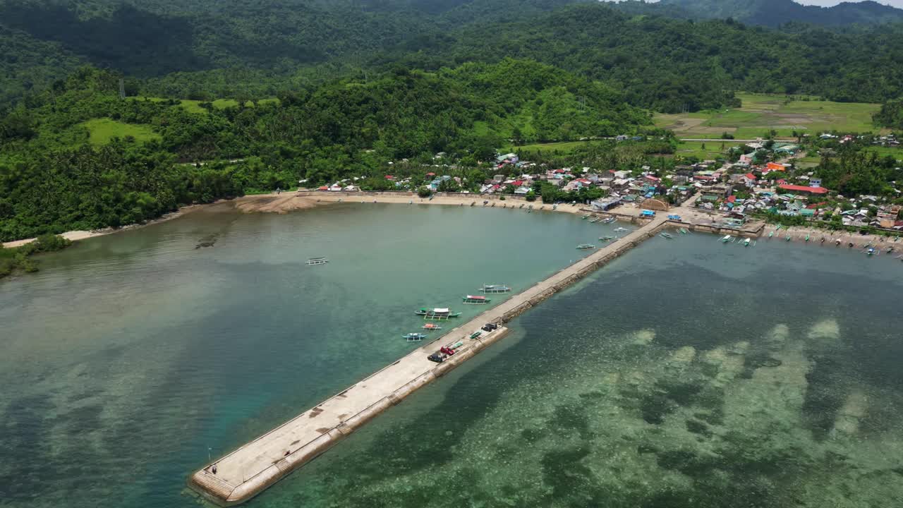 Panoramic aerial time-lapse of Codon port extending into the reef along the scenic coastal village of Catanduanes, Luzon, Philippines