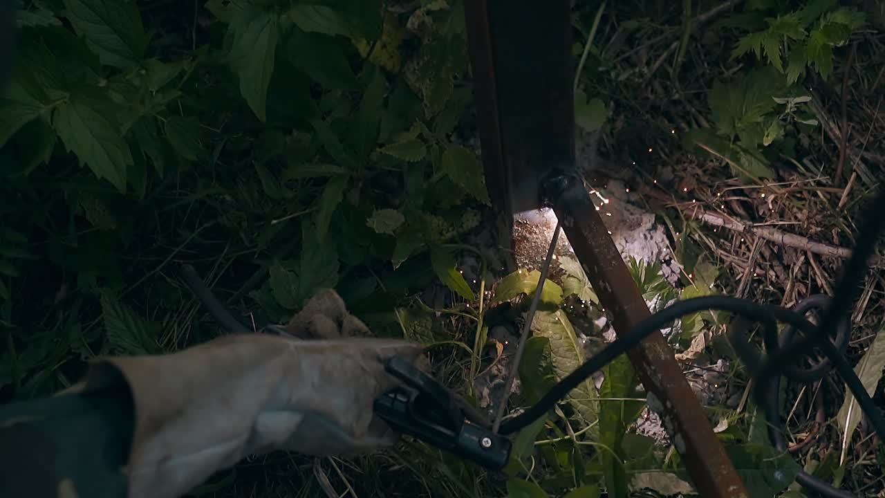 천천히 가까이 보이는 용접기가 철도를 울타리 지원으로 고정합니다.