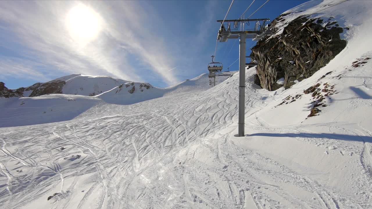 plano general de un telesilla que se mueve sobre una ladera nevada con pistas de esquí fuera de pista en la nieve