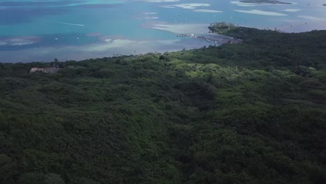 Overview-of-east-honolulu-oahu-hawaii-and-the-jungle-below-revealing-the-beautiful-ocean-scape-sandbars-and-islands,-AERIAL-DOLLY-BACK-TILT-UP