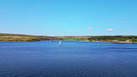 un maravilloso lago azul, el embalse de winscar en yorkshire, proporciona el escenario perfecto para un evento de vela