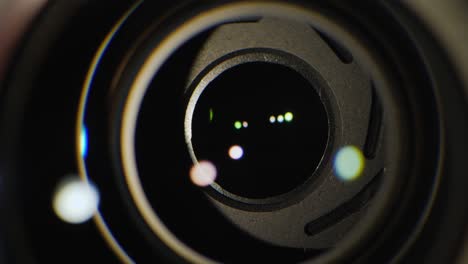 a close-up of the lens of a video camera. the light source illuminates the lenses, then goes into darkness