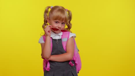 Playful-happy-teen-child-kid-girl-in-school-uniform-winking-eye,-looking-at-camera-with-smile