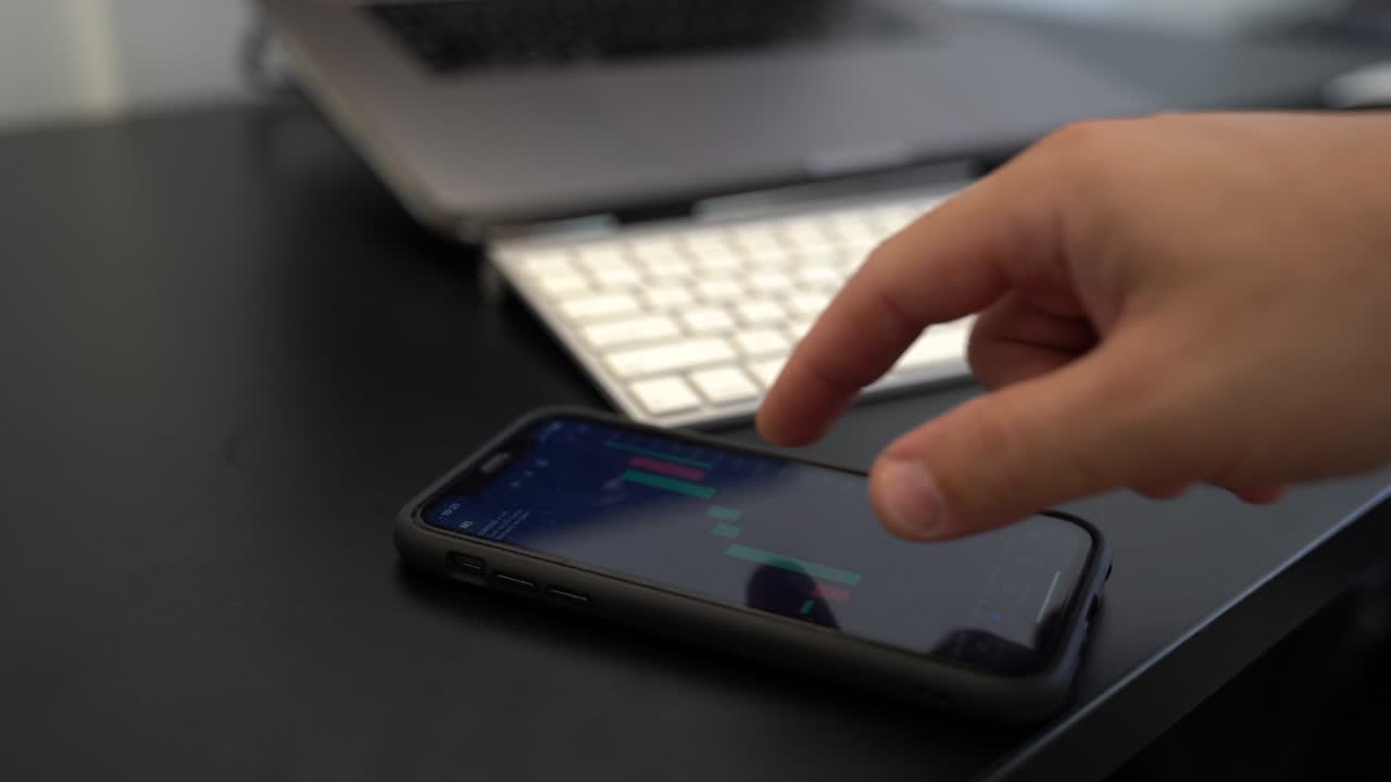 vídeo de hombre de negocios que usa el teléfono inteligente para negociar en el mercado de valores