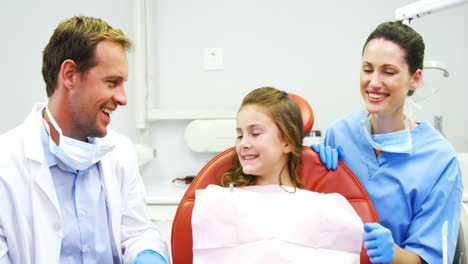 portrait of smiling dentists and young patient showing thumbs up