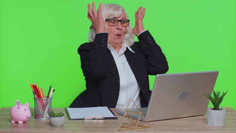 senior business woman analysing paperwork documents shocked by sudden win victory, good news, wow