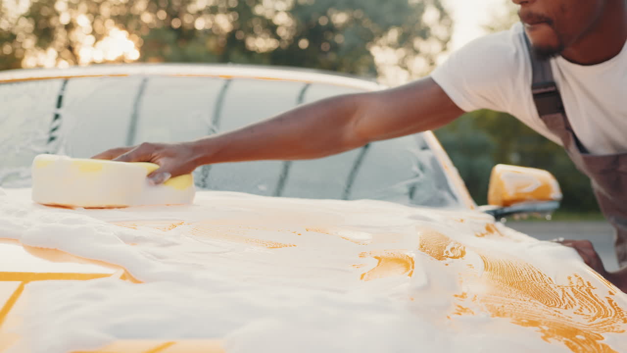 Man washing a yellow car