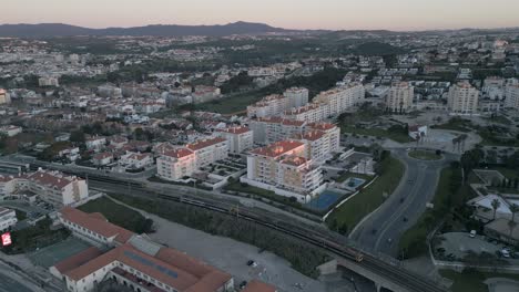 Vista-Aérea-De-Un-Tren-Que-Pasa-Con-Turistas-Y-Trabajadores-Cerca-De-La-Playa-De-São-Pedro-En-Un-Día-Soleado,-Portugal