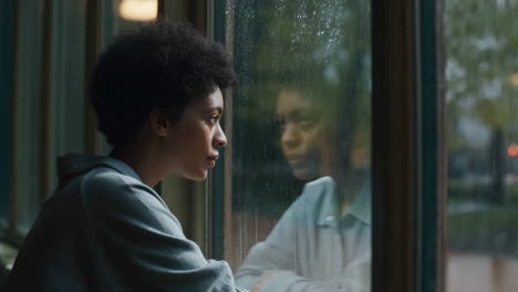 woman looking out a rainy window