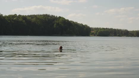 Hombre-Sin-Camisa-Nada-En-El-Lago-De-Jezioro-Glebokie-En-Polonia