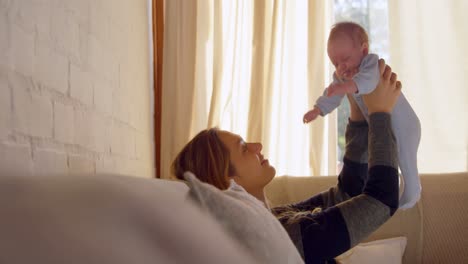 mother holding her baby face in living room 4k