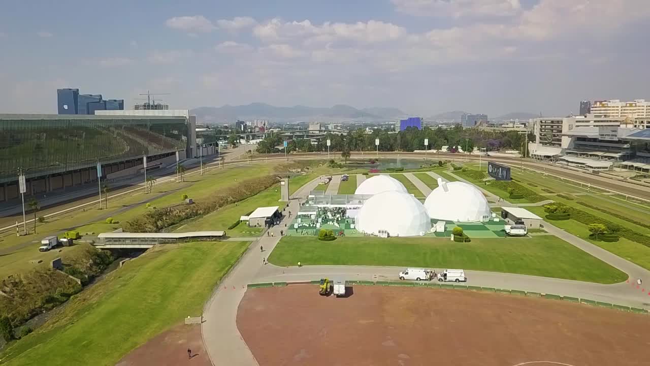 Aerial view of spherical tents inside a stadium.