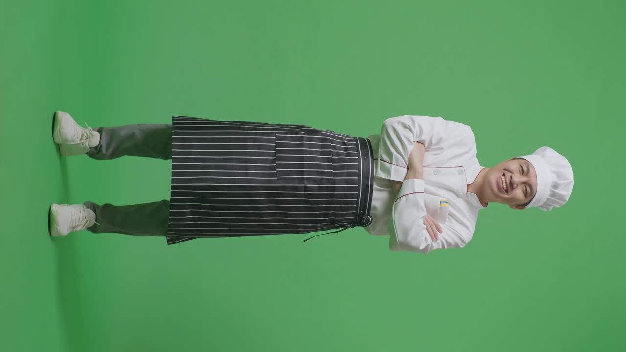 Full Body Of Asian Man Chef Smiling And Crossing His Arms To Camera While Standing In The Green Screen Background Studio
