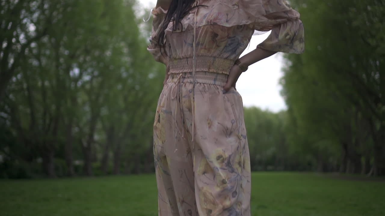 카메라를 모델링하고 바라보는 동안 화려한 히스패닉 갈색 머리를 아래로 기울입니다.