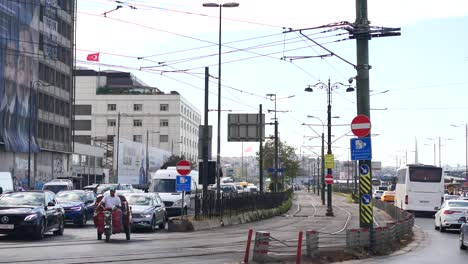 calle ocupada en estambul con tráfico, coches, personas y una vía de tranvía