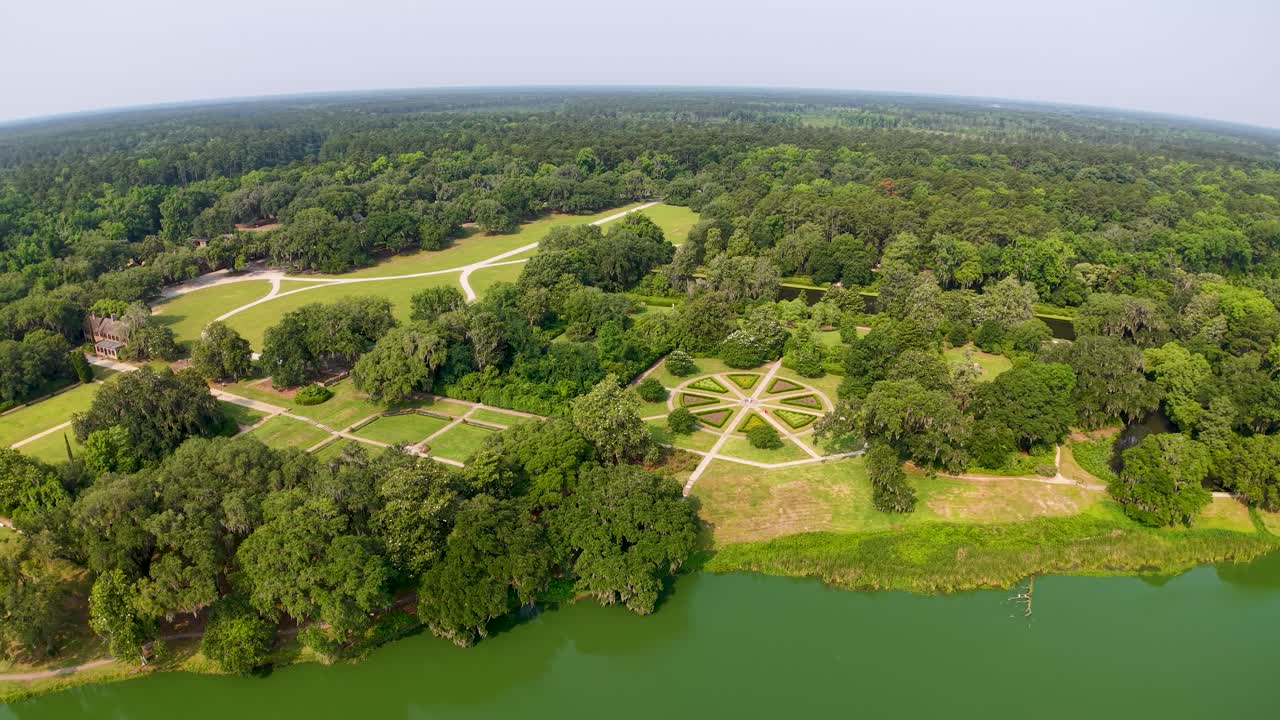 Luchtfoto met een drone van een weelderig groen park met symmetrische gazons en paden met bomen langs een kronkelende rivier in Charleston, South Carolina