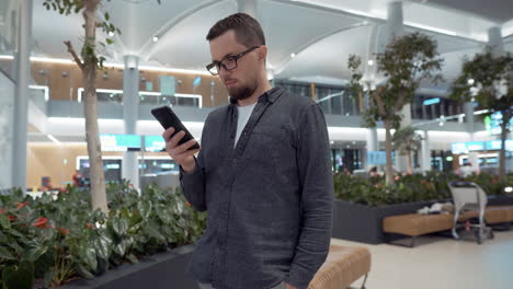 hombre usando un teléfono inteligente en el aeropuerto