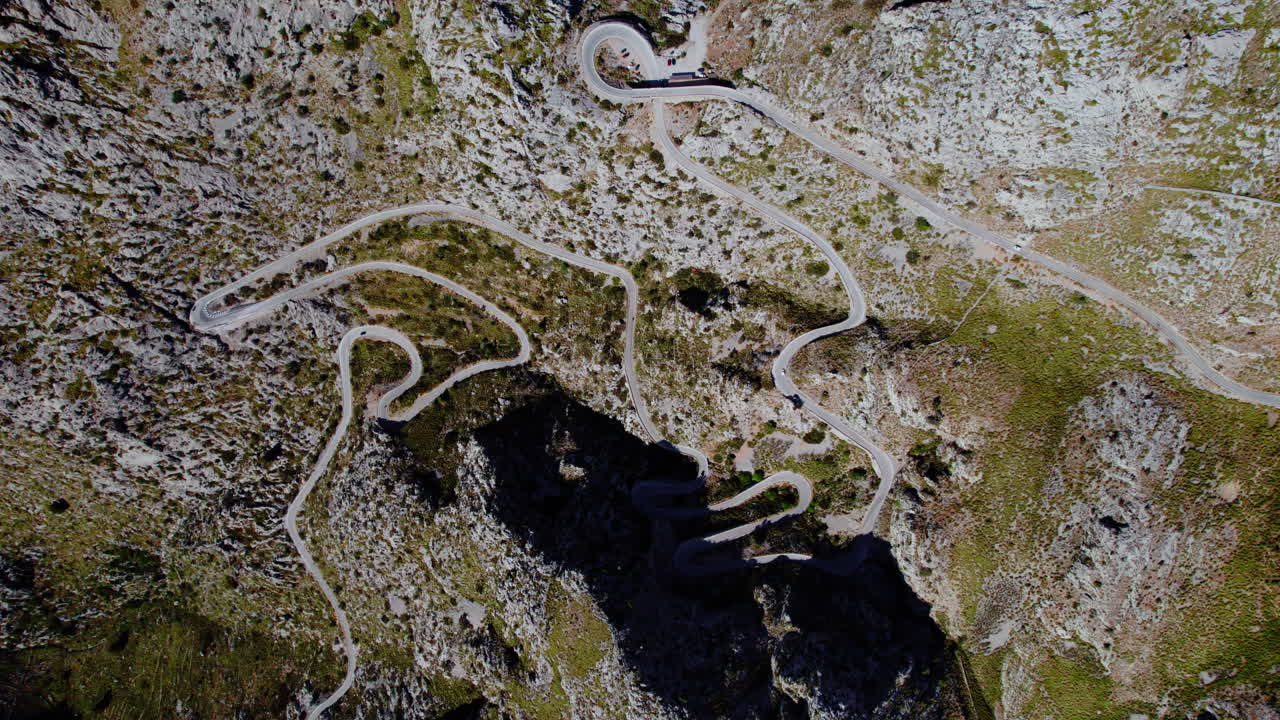 carretera sinuosa de nus de sa corbata en el paso de montaña coll dels reis en mallorca, españa - aérea de arriba hacia abajo