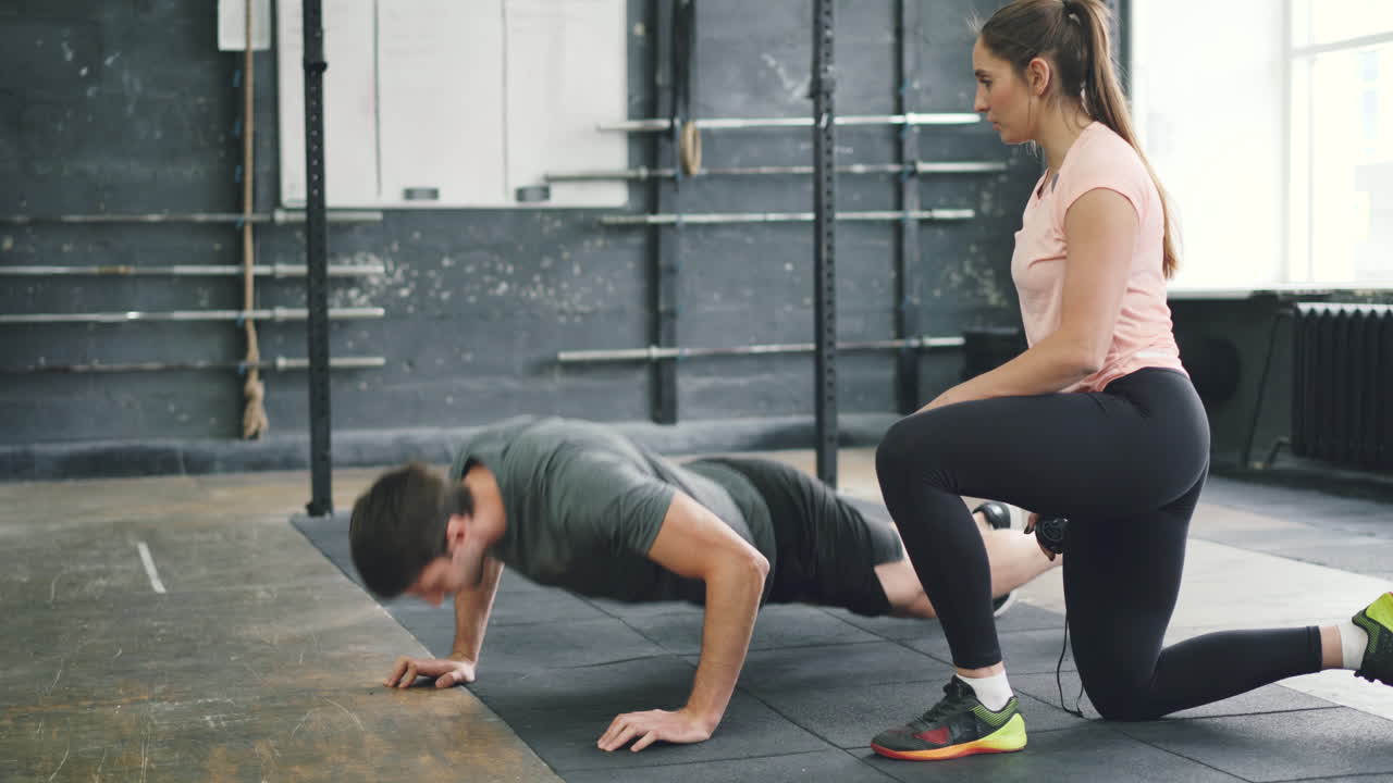 Man Performing Push-ups with Female Fitness Instructor