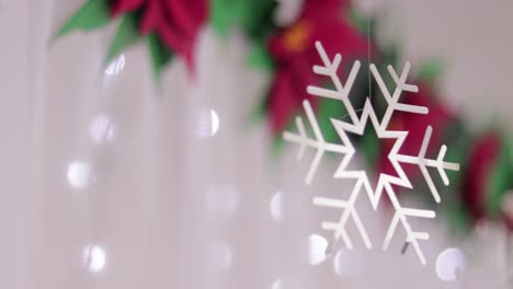 Christmas-decorations.-Poinsettias-and-silver-snowflake.-Blurred-background