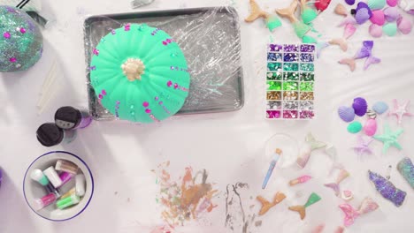 decorating art pumpkins with rhinestones, mermaid tails, and seashells in mermaid theme