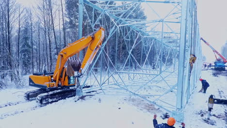 máquina industrial en la instalación de la torre de alta tensión. trabajo de electricidad de energía