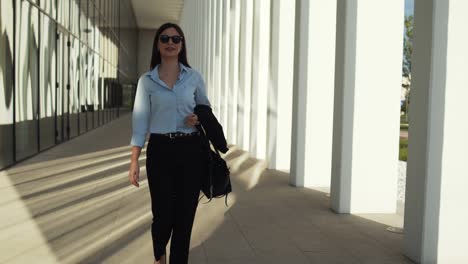 business woman walking outdoors in front of office building