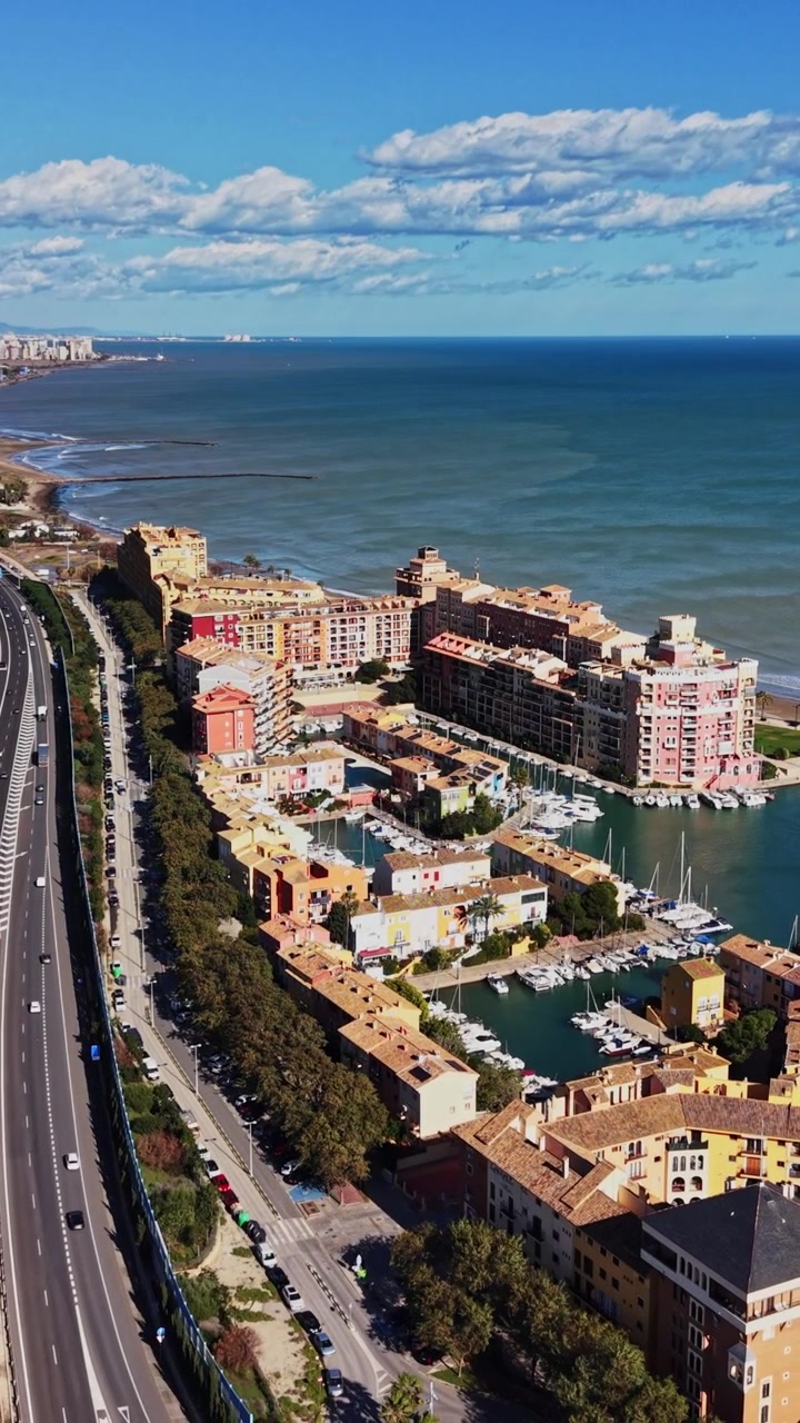Kystudsigt over Spanien med bygninger ved havet og motorvej
