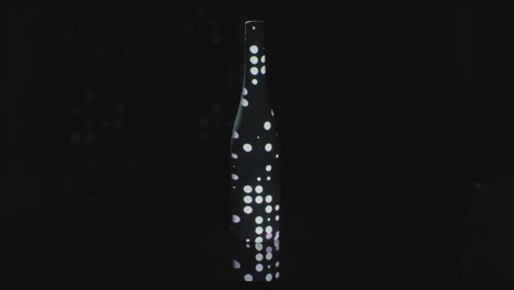 white circles and spots appear on black bottle against black background