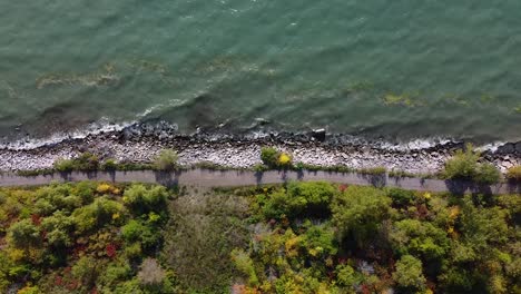 waves breaking on rocky shoreline beach with waterfront walking trail