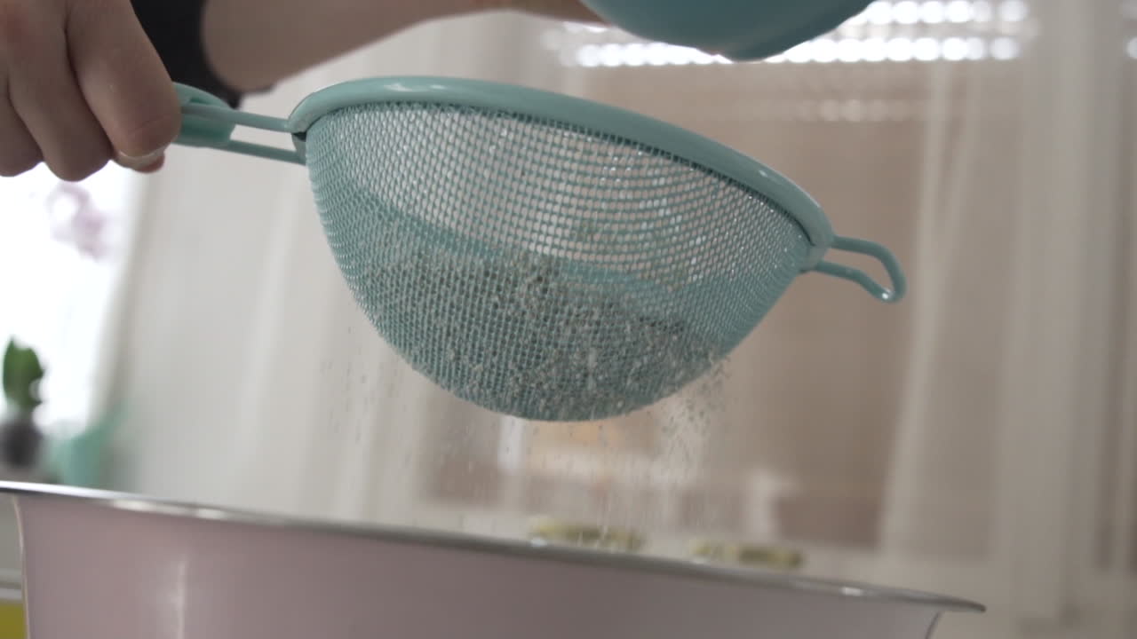 부엌에서 밀가루를 체질하고, 가까운 샷은 베이킹 준비를 합니다.