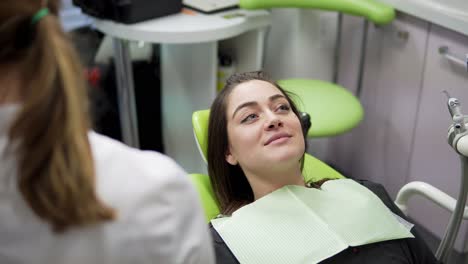 young female doctor taking on a napkin for her patient. oral hygiene and dental care: doctor dentist working with patient in dental clinic. healthcare concept.