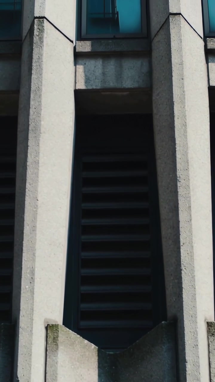 Video vertical: Cámara inclinándose hacia arriba mostrando una celosía exterior, un alféizar y una ventana azul para mostrar un haz de luz.