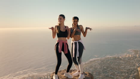 best friends dancing on mountain top celebrating successful hiking adventure with funny victory dance