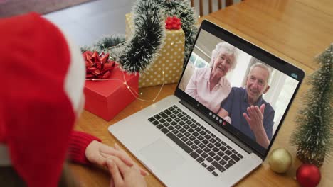 Mujer-Caucásica-Teniendo-Videollamada-Navideña-En-Una-Computadora-Portátil-Con-Abuelos-Caucásicos-En-La-Pantalla