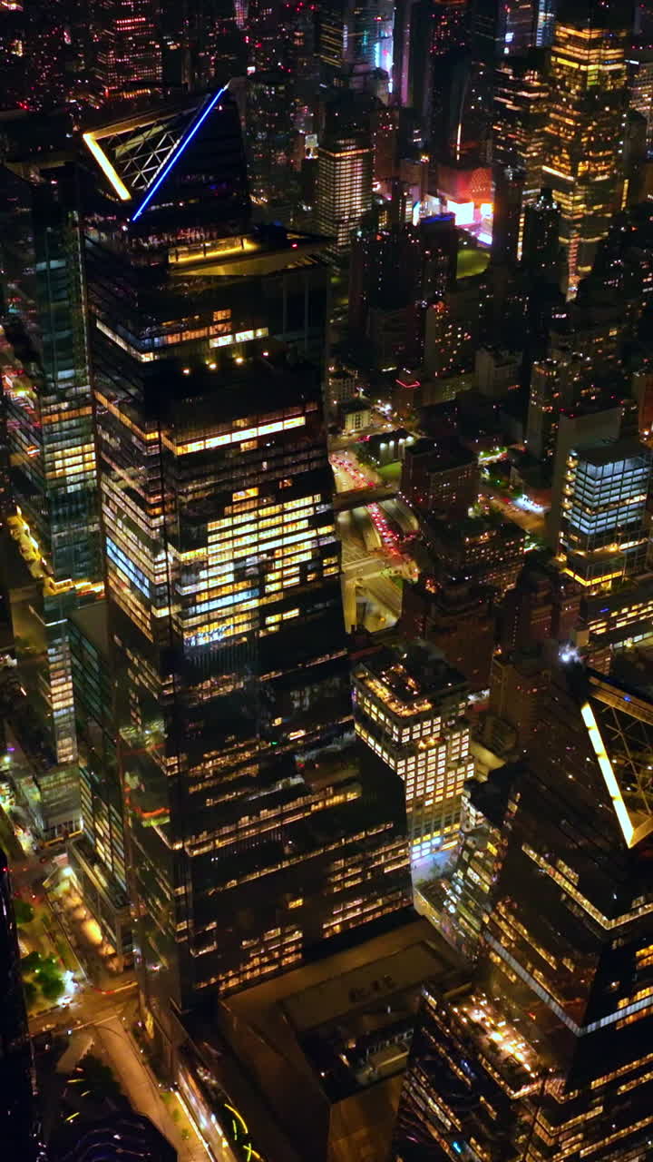 Impressive diverse architecture of vibrant New York. Beautifully shining metropolis at night. Aerial perspective. Vertical video