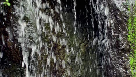panorámica de cascada entre piedras con musgo