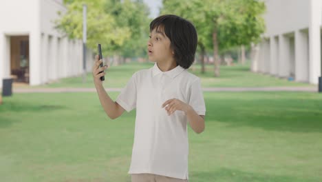 Niño-Indio-Hablando-Por-Videollamada-En-El-Parque