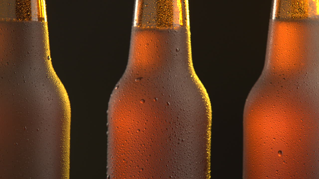 Three beer bottle rotating on black background