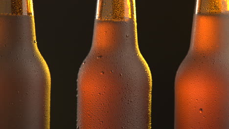 three beer bottle rotating on black background